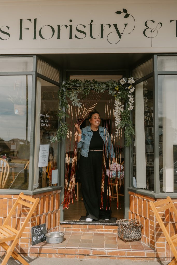 happy owner stood by door of claires floristry and tea rooms